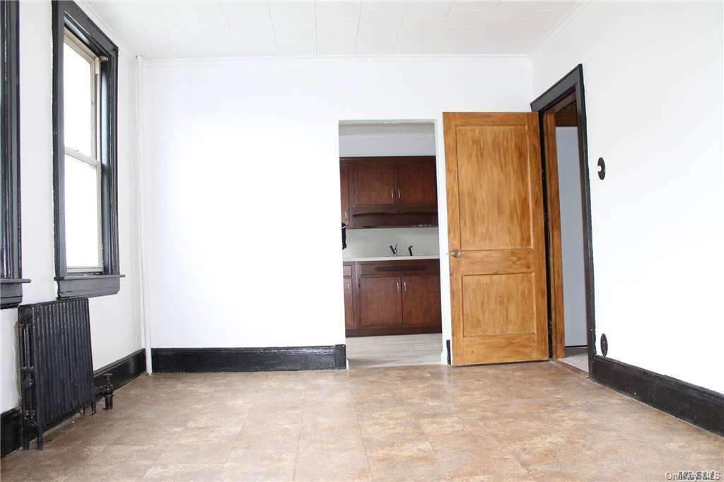 59-12 71st Street Queens, NY 11378 - Photo 8 of 26 a view of an empty room with a window