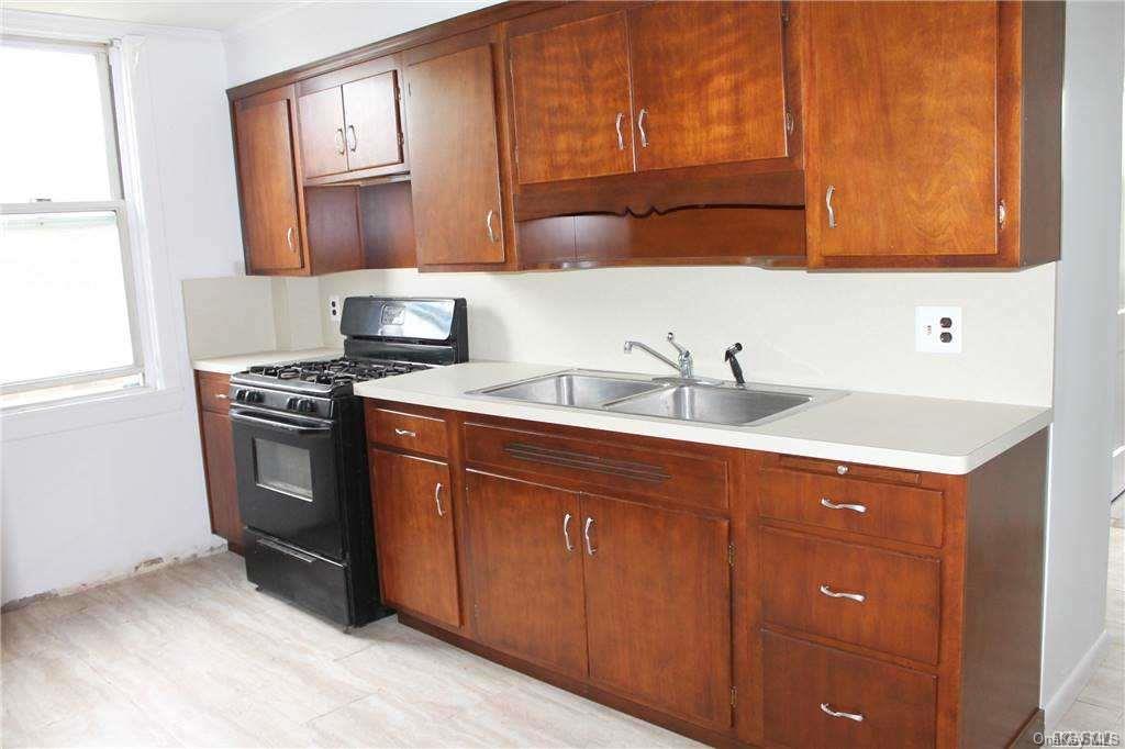 59-12 71st Street Queens, NY 11378 - Photo 10 of 26 a kitchen with stainless steel appliances granite countertop a sink stove and cabinets