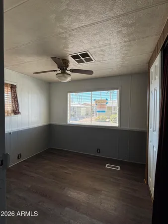 a view of a room with wooden floor and ceiling fan