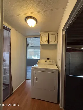 an empty room with wooden floor cabinet and windows