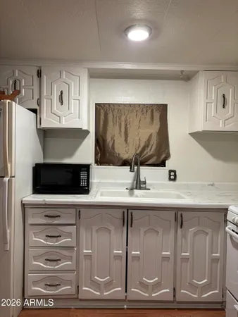 a kitchen with white cabinets and white appliances