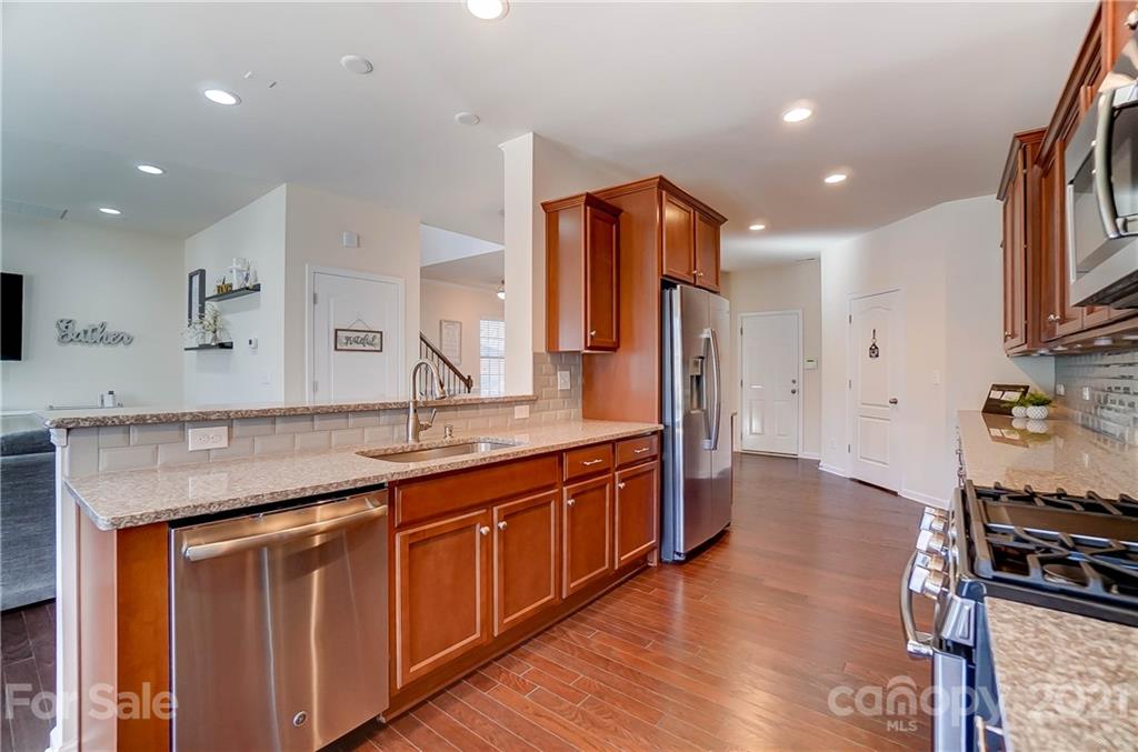 237 Butterfly Place, Unit 198 Tega Cay, SC 29708 - Photo 13 of 26 a kitchen with stainless steel appliances granite countertop a sink stove and refrigerator