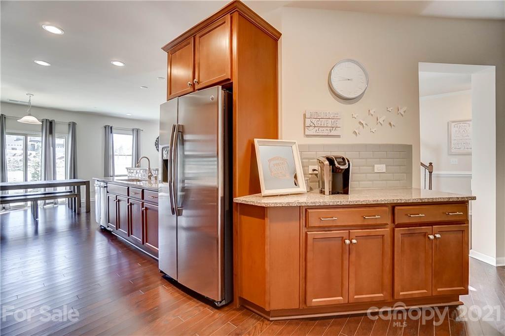 237 Butterfly Place, Unit 198 Tega Cay, SC 29708 - Photo 14 of 26 a kitchen with stainless steel appliances granite countertop a refrigerator a stove and a wooden floors