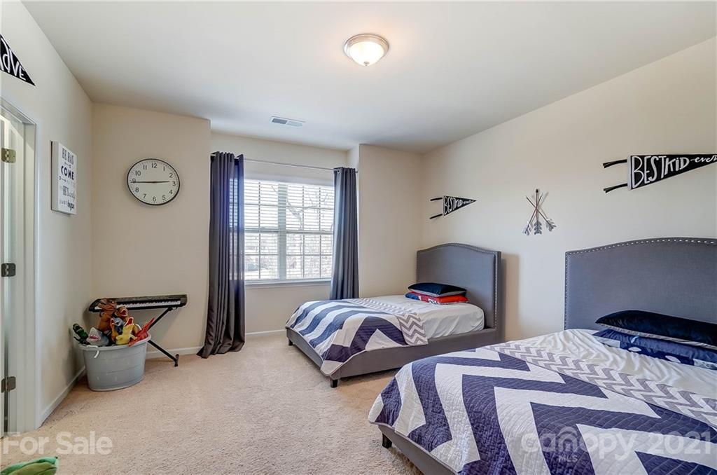 237 Butterfly Place, Unit 198 Tega Cay, SC 29708 - Photo 21 of 26 a bedroom with two beds and a large window