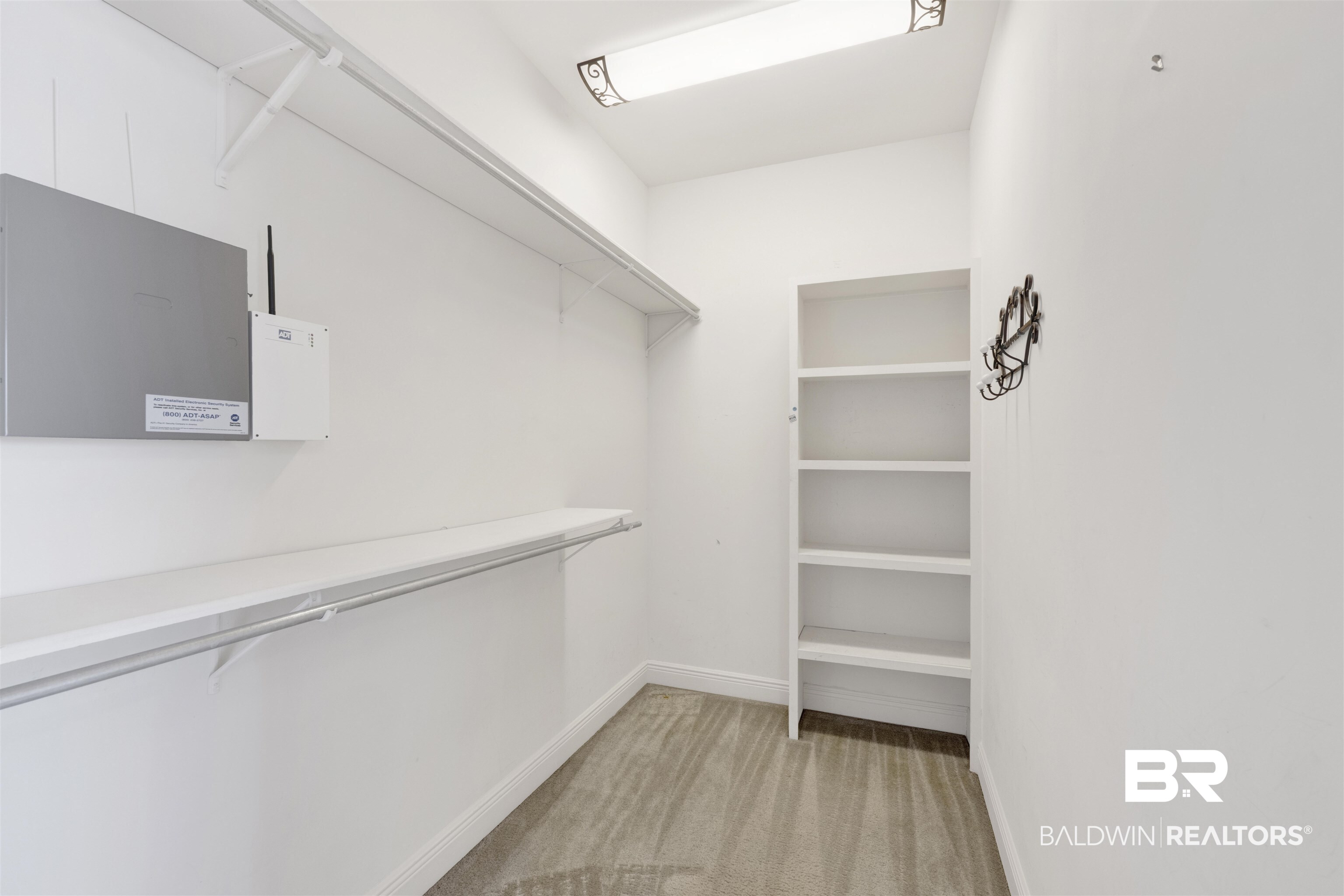 12944 Anna's Way Stapleton, AL 36578 - Photo 55 of 64 Walk-in closet with carpet flooring, a built-in shelving unit, and overhead lighting