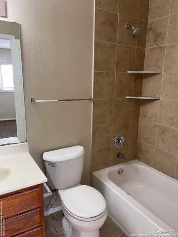 a white toilet and tub sitting next to a bathroom sink