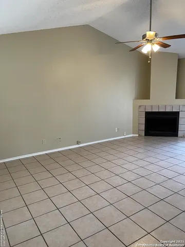 a view of a livingroom with a chandelier fan and fire place
