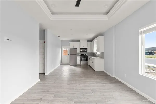 a view of a kitchen with wooden floor and windows
