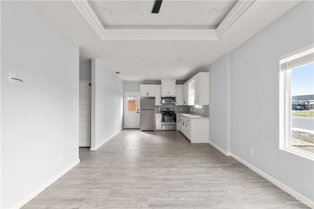 11018 North 33rd Lane, Unit 2 McAllen, TX 78504 - Photo 4 of 17 a view of a kitchen with wooden floor and windows