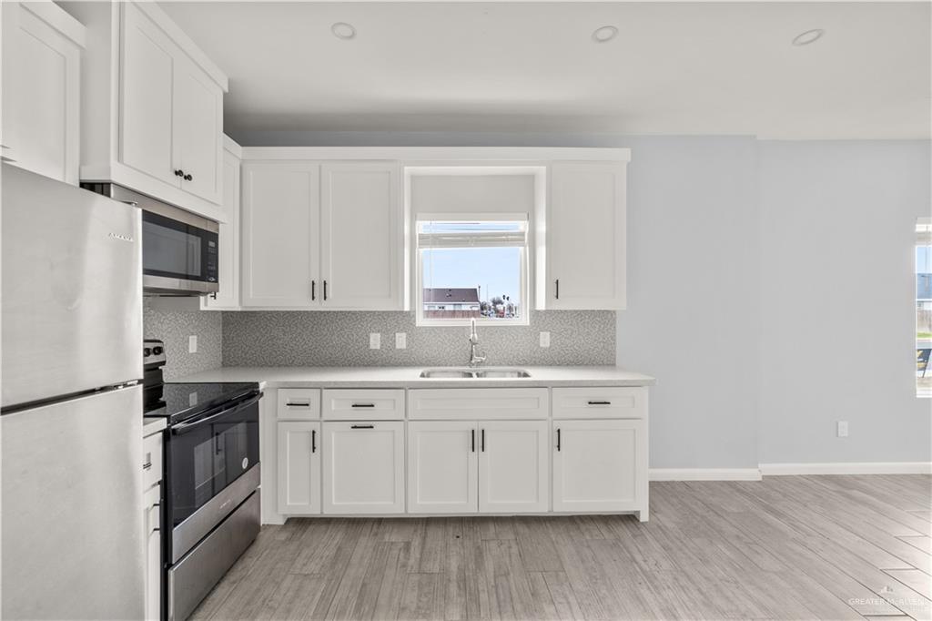 11018 North 33rd Lane, Unit 2 McAllen, TX 78504 - Photo 5 of 17 a kitchen with a sink stove and cabinets