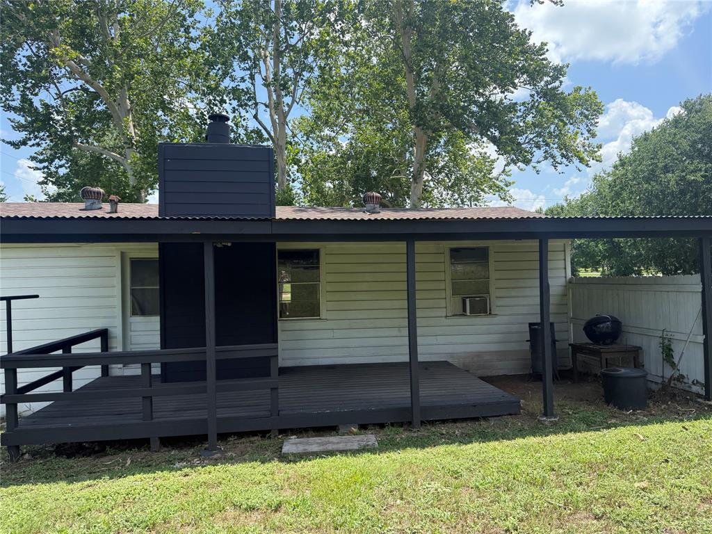 1825 East Pierce Street Luling, TX 78648 - Photo 15 of 16 An inviting backyard deck, ideal for outdoor gatherings, extends from the home's side entrance.