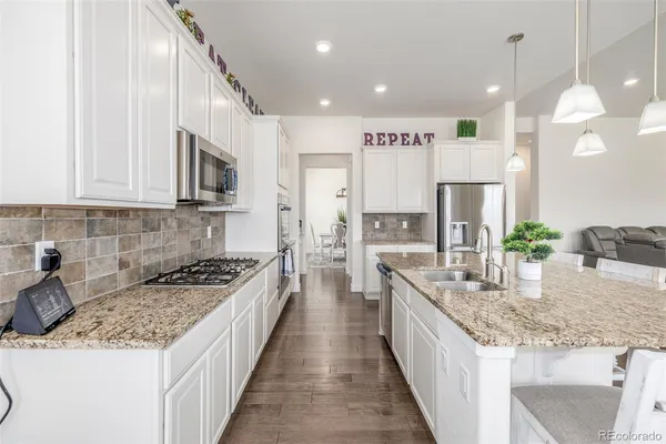 a kitchen with stainless steel appliances granite countertop a stove a sink a refrigerator and a oven