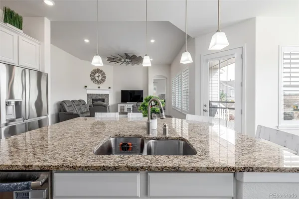 a kitchen with granite countertop a sink a counter top space appliances and cabinets