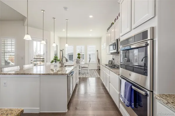 a large kitchen with stainless steel appliances lots of counter space and wooden floor