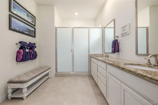 a spacious bathroom with a granite countertop sink and a mirror
