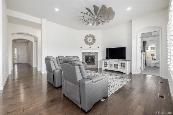 a living room with furniture a flat screen tv and kitchen view