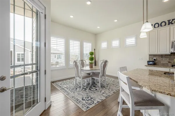 a dining room with wooden floor and a chandelier