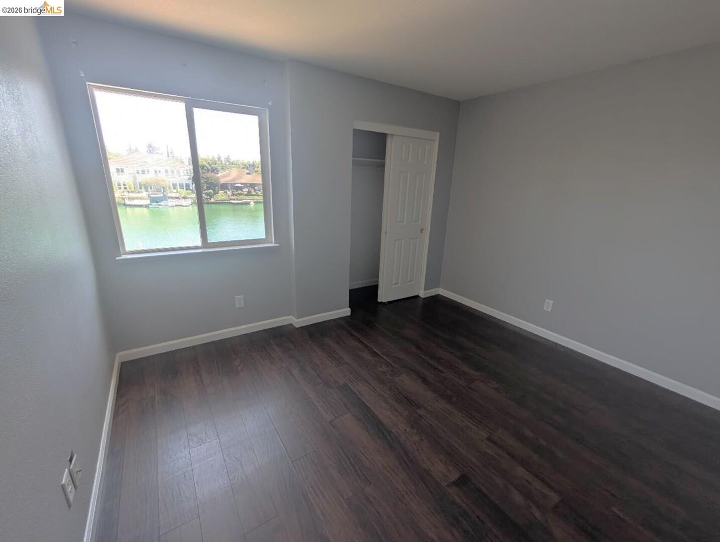 4958 Bay View Circle Stockton, CA 95219 - Photo 3 of 24 unfurnished bedroom with a closet and dark wood-style flooring