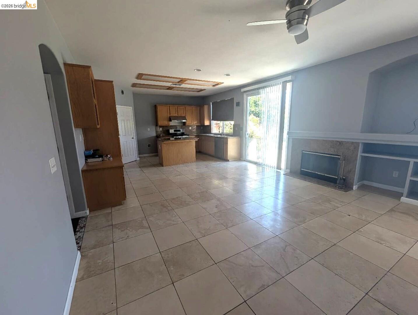 4958 Bay View Circle Stockton, CA 95219 - Photo 24 of 24 kitchen with a center island, a ceiling fan, wood finish cabinets, open floor plan, and stainless steel stove