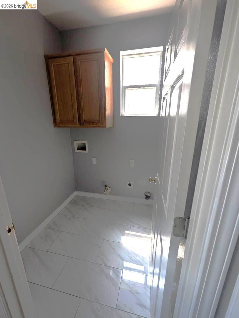 4958 Bay View Circle Stockton, CA 95219 - Photo 6 of 24 laundry room with hookup for a washing machine, cabinet space, light marble finish floors, gas dryer hookup, and hookup for an electric dryer