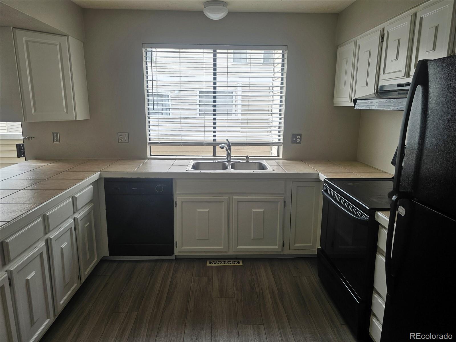 1050 South Monaco Parkway, Unit 93 Denver, CO 80224 - Photo 4 of 20 a kitchen with stainless steel appliances a sink stove and cabinets