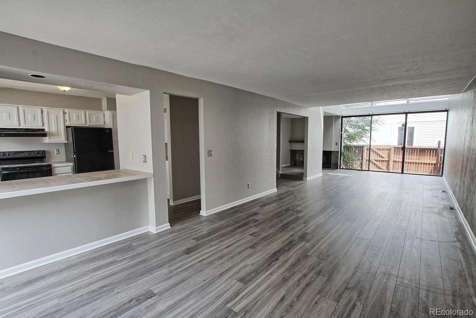 1050 South Monaco Parkway, Unit 93 Denver, CO 80224 - Photo 5 of 20 an empty room with wooden floor and fireplace