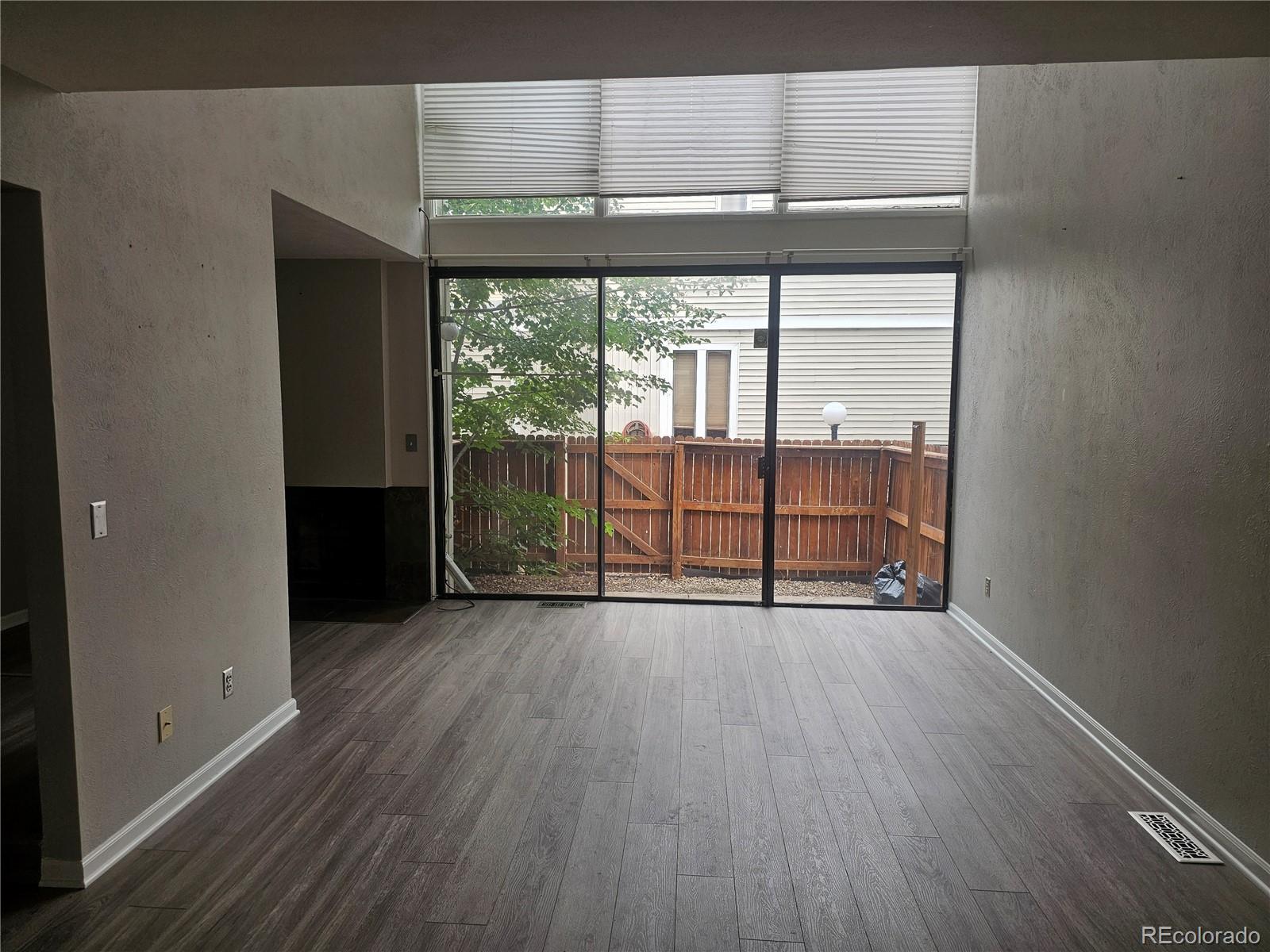 1050 South Monaco Parkway, Unit 93 Denver, CO 80224 - Photo 7 of 20 an empty room with wooden floor and windows