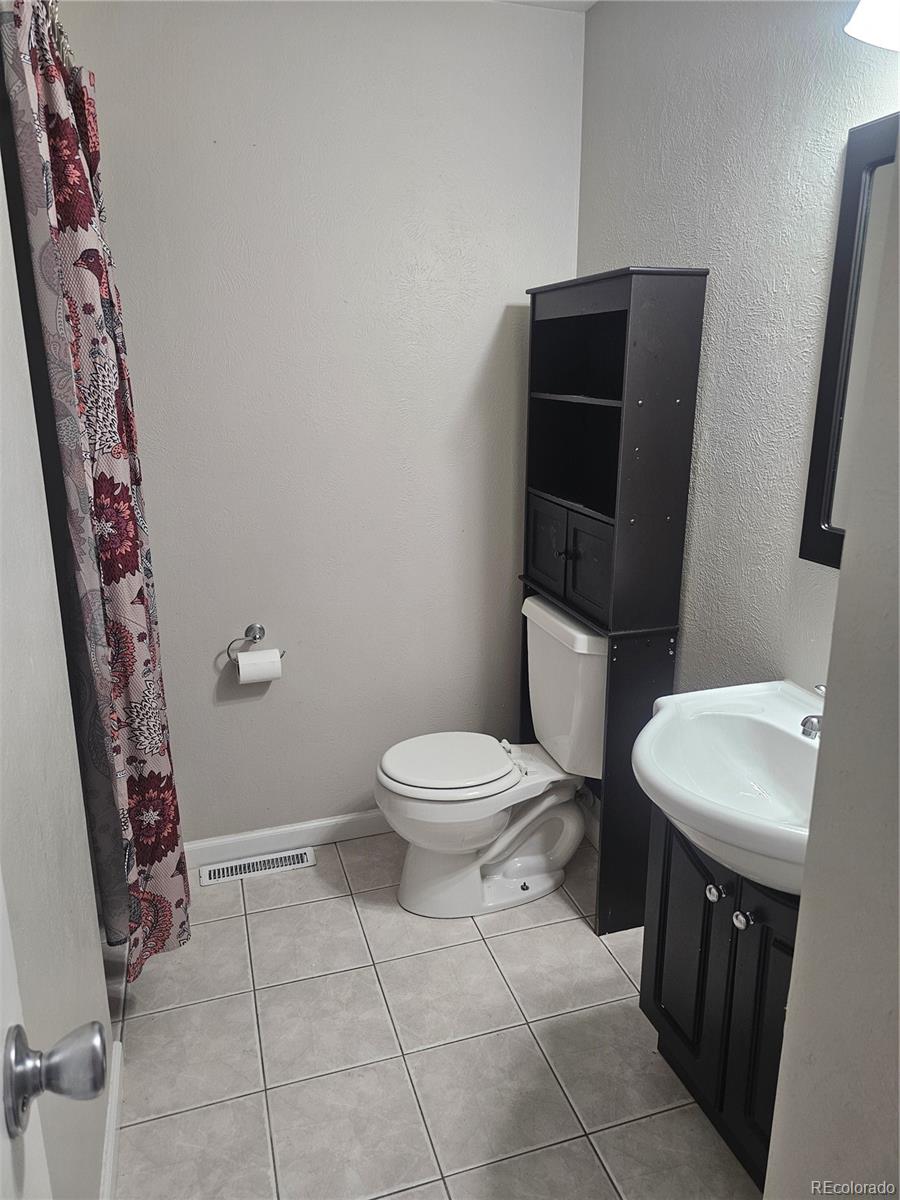 1050 South Monaco Parkway, Unit 93 Denver, CO 80224 - Photo 9 of 20 a bathroom with a toilet a sink and mirror