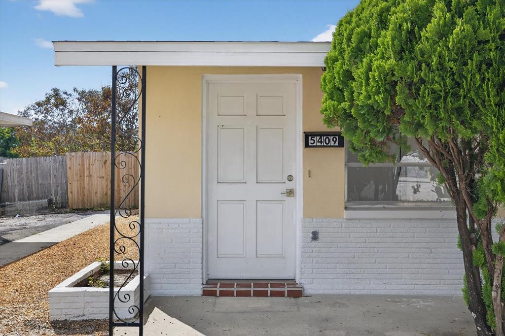 a front view of a house with a tree