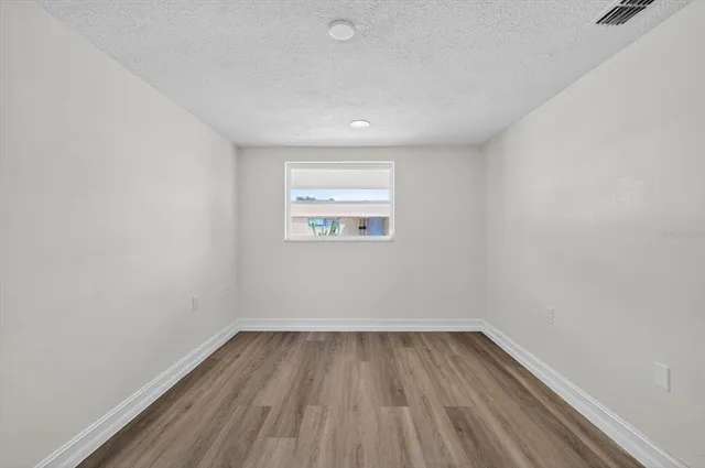 a view of a room with wooden floor and window