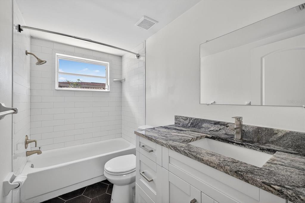 5409 Oceanic Road Holiday, FL 34690 - Photo 14 of 34 a bathroom with a granite countertop sink toilet and bathtub
