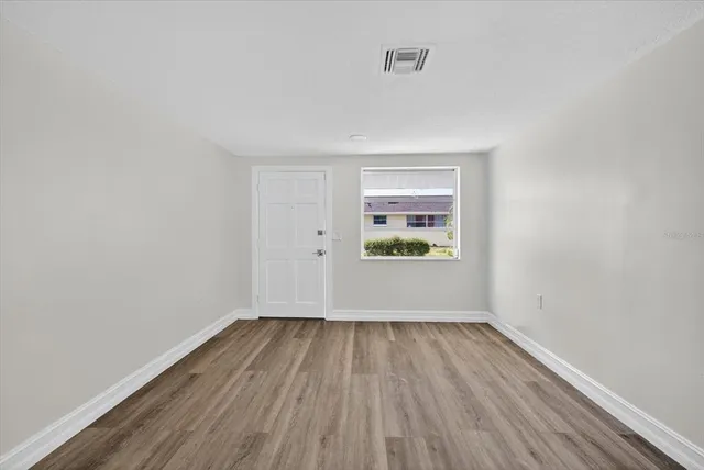 a view of room with window and wooden floor