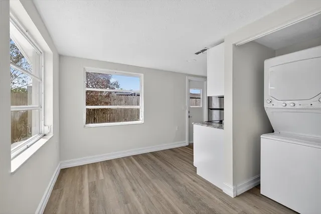 a view of empty room with a window and wooden floor