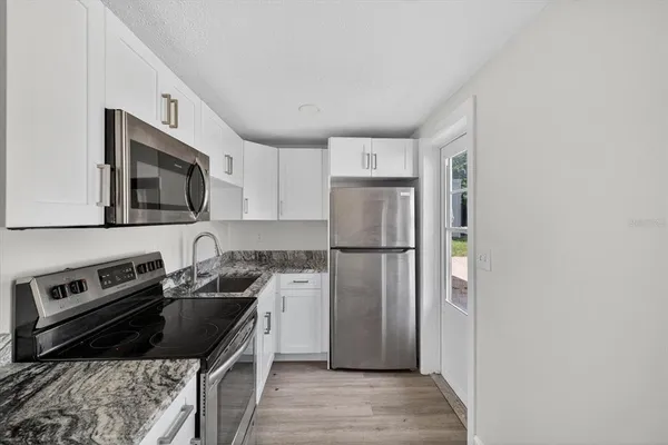 a kitchen with a refrigerator stove and sink