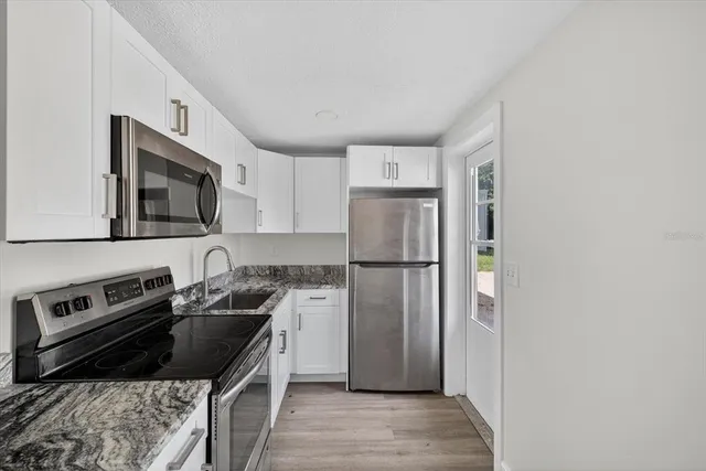 a kitchen with a refrigerator stove and sink