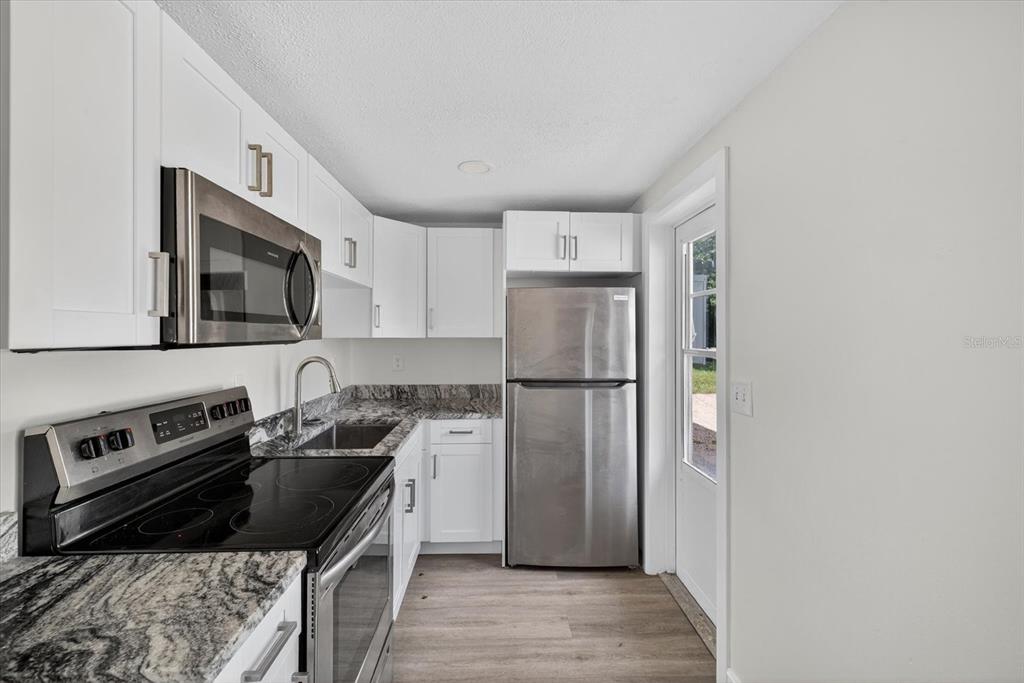 5409 Oceanic Road Holiday, FL 34690 - Photo 21 of 34 a kitchen with a refrigerator stove and sink
