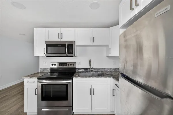 a kitchen with white cabinets stainless steel appliances and sink