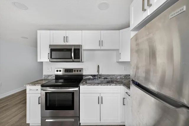 a kitchen with white cabinets stainless steel appliances and sink
