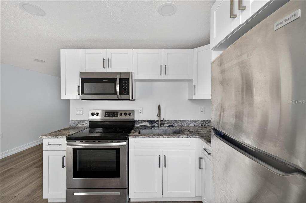 5409 Oceanic Road Holiday, FL 34690 - Photo 23 of 34 a kitchen with white cabinets stainless steel appliances and sink