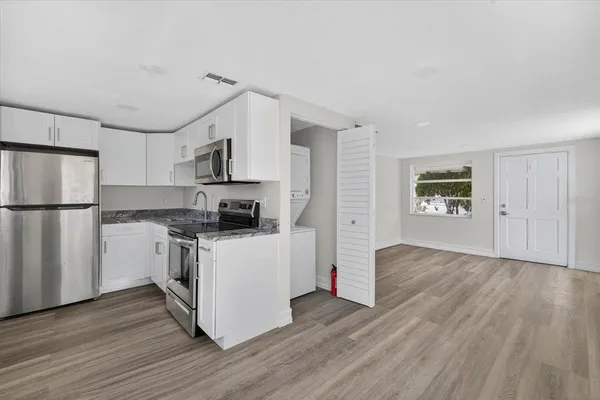 a kitchen with a refrigerator and a stove top oven