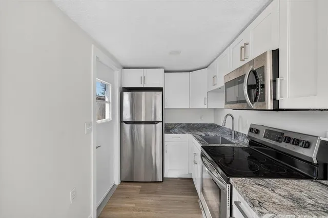 a kitchen with stainless steel appliances granite countertop a refrigerator sink and stove