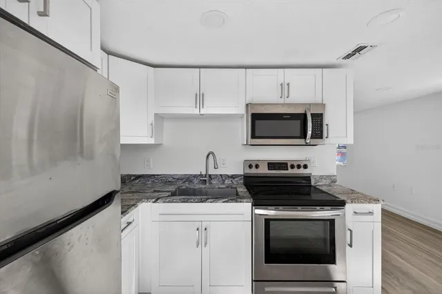 a kitchen with granite countertop a stove and a microwave