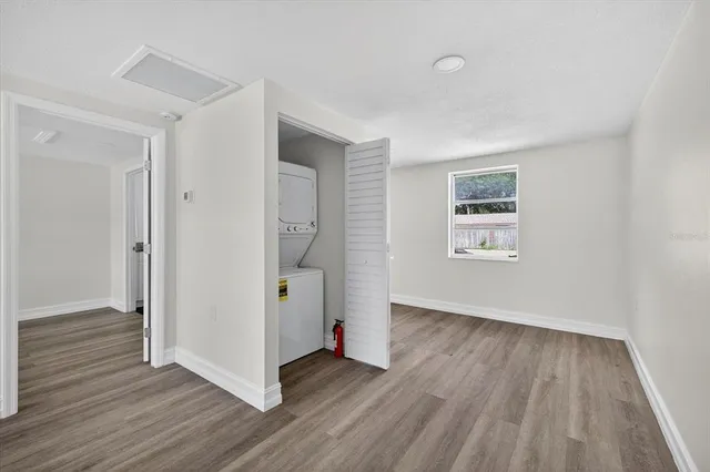 a view of a hallway with wooden floor and a bathroom