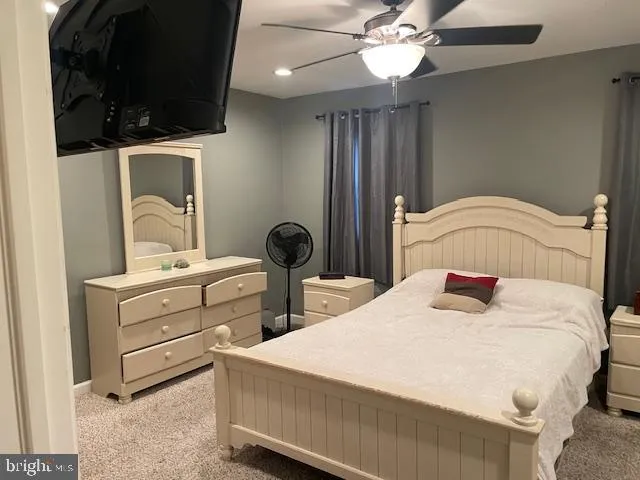 a bedroom with a bed and ceiling fan