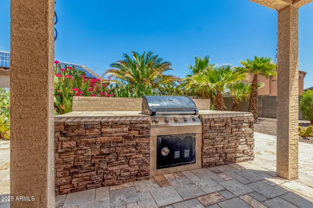 a backyard of a house with barbeque oven table and chairs