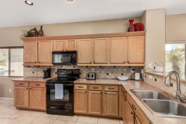 a kitchen with stainless steel appliances granite countertop a sink stove and cabinets