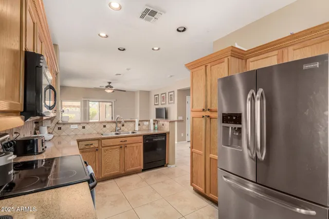 a kitchen with stainless steel appliances granite countertop a refrigerator a stove and a sink