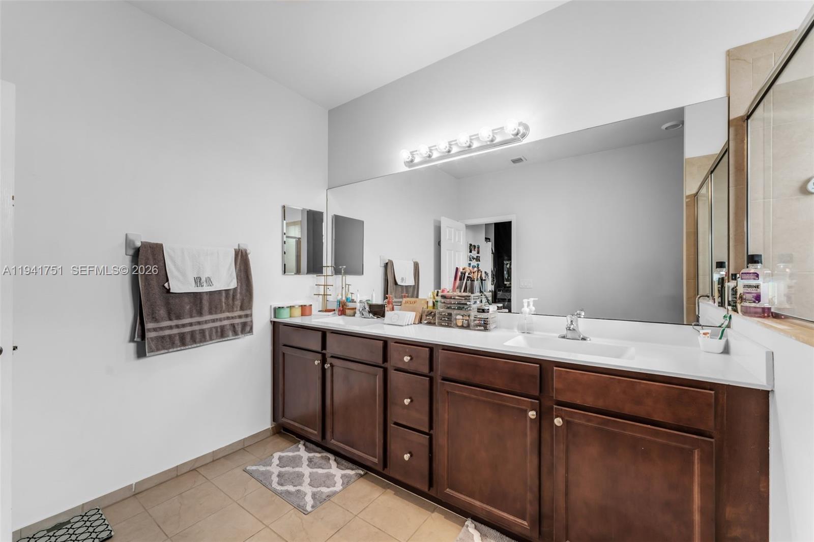 3763 Southeast 2nd Street Homestead, FL 33033 - Photo 14 of 48 a bathroom with a double vanity sink a mirror and shower