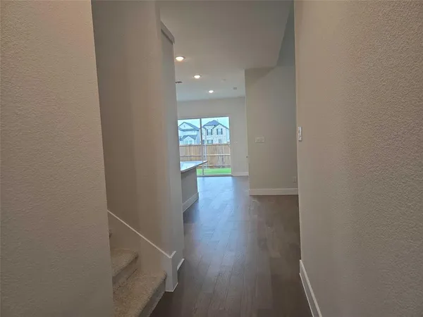 a hallway with wooden floor door and entryway
