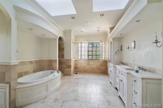 8355 Providence Road Charlotte, NC 28270 - Photo 12 of 36 a bathroom with a tub a sink a mirror and a shower